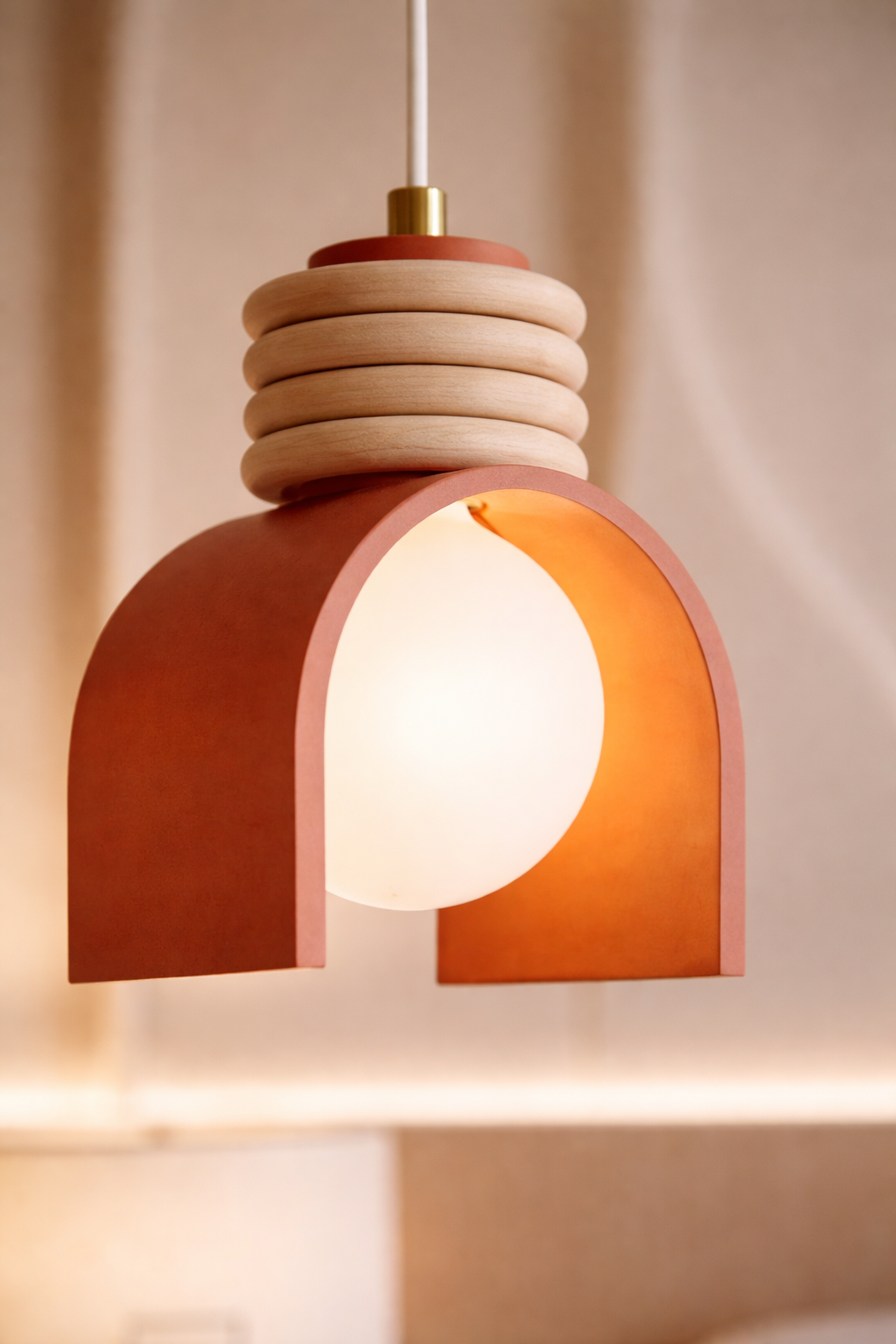 Modern pendant light with a warm glow on a neutral styled interior decor background