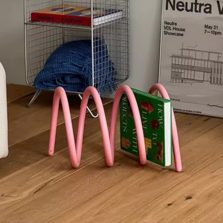 Ripple rack a unique modern colourful book rack and bookend for interior design and style in pink with a book on it