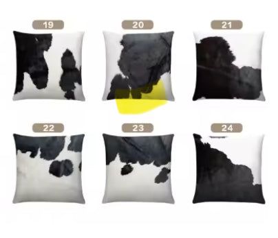Set of six real cow hide pillows with black and white hide patterns on a white background