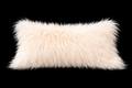 White fluffy Mongolian lamb fur lumbar pillow on a black background 